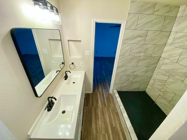 bathroom featuring vanity, hardwood / wood-style floors, and a tile shower