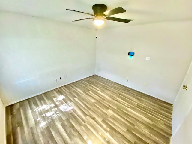 spare room with ceiling fan and light wood-type flooring