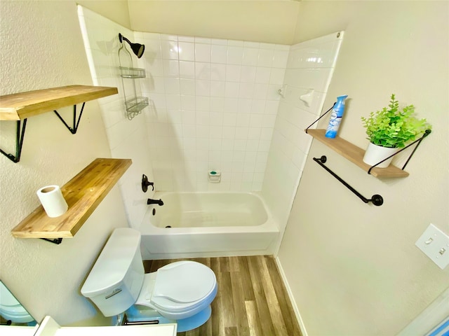 bathroom featuring toilet, tiled shower / bath, and hardwood / wood-style floors