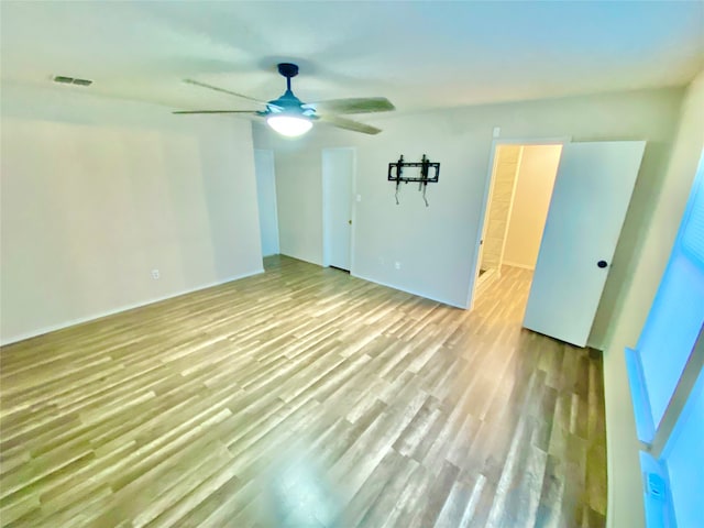 empty room with light hardwood / wood-style floors and ceiling fan