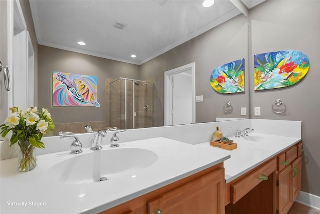 bathroom with ornamental molding, vanity, and a shower with shower door