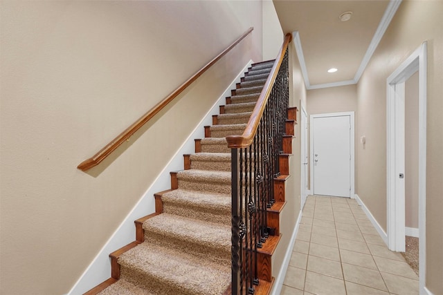 stairs with tile patterned floors and ornamental molding