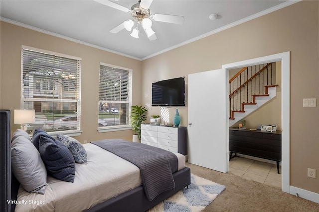 carpeted bedroom featuring ceiling fan and crown molding