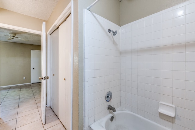 bathroom with a textured ceiling, tile patterned flooring, and tiled shower / bath