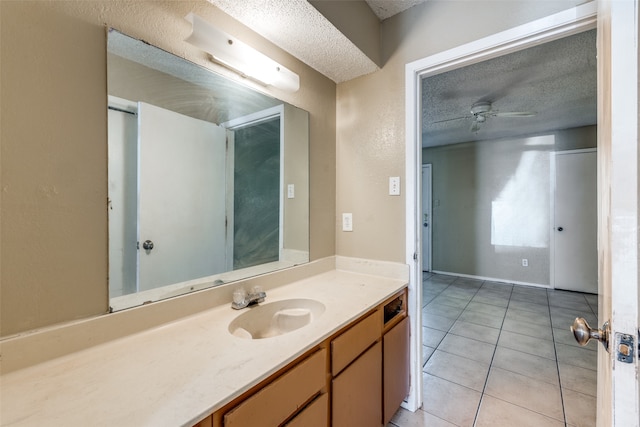 bathroom with vanity, a textured ceiling, ceiling fan, and tile patterned flooring