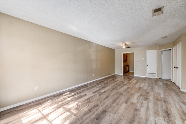 unfurnished room with a textured ceiling, light hardwood / wood-style floors, and ceiling fan