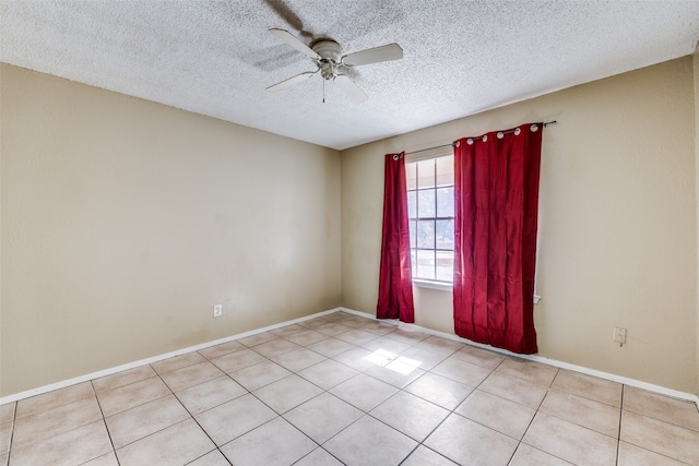 spare room with ceiling fan, a textured ceiling, and light tile patterned floors