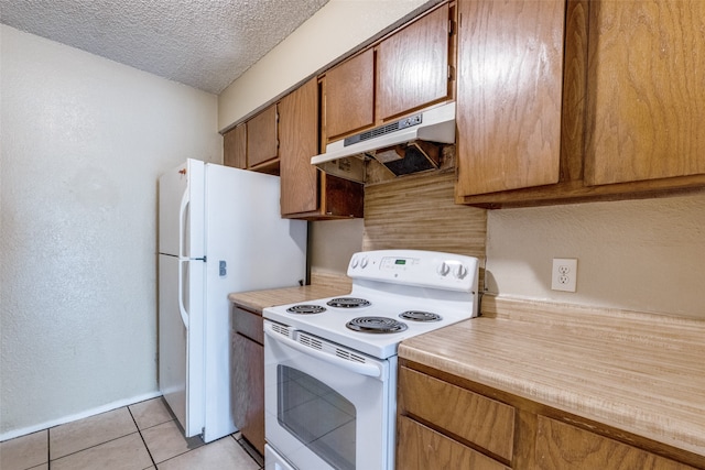 kitchen with white appliances, a textured ceiling, and light tile patterned floors