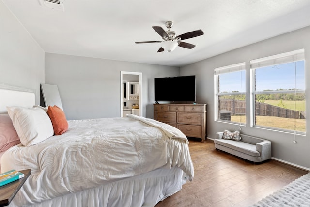 bedroom with ceiling fan, light hardwood / wood-style flooring, and ensuite bathroom