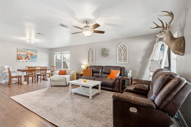 living room featuring hardwood / wood-style floors and ceiling fan