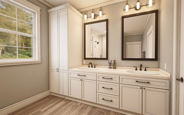 bathroom with vanity, ornamental molding, wood-type flooring, and walk in shower