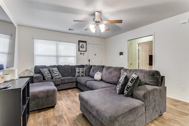 living room featuring light hardwood / wood-style flooring and ceiling fan with notable chandelier