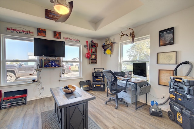 office space with hardwood / wood-style floors, a raised ceiling, and ceiling fan