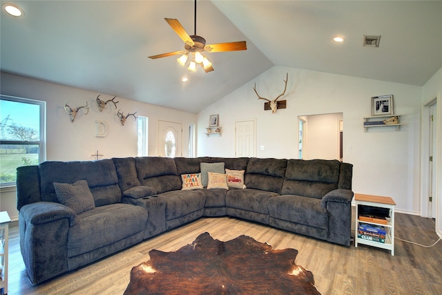 living room with ceiling fan, wood-type flooring, a wealth of natural light, and lofted ceiling