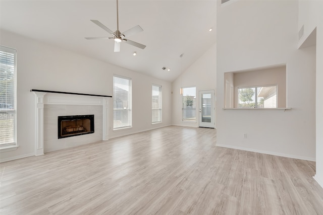 unfurnished living room with light hardwood / wood-style floors, high vaulted ceiling, and a healthy amount of sunlight