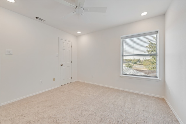 empty room featuring light colored carpet and ceiling fan