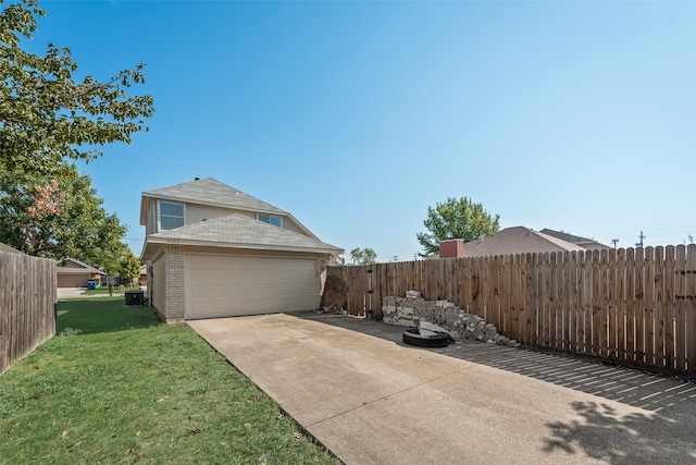 view of side of home with a garage, cooling unit, and a lawn