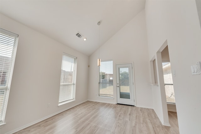 unfurnished room featuring high vaulted ceiling, light hardwood / wood-style floors, and plenty of natural light