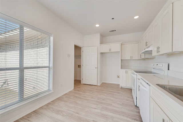 kitchen featuring sink, light stone countertops, light wood-type flooring, white cabinetry, and white appliances