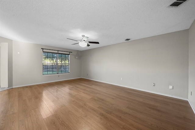 empty room featuring a textured ceiling, wood-type flooring, and ceiling fan