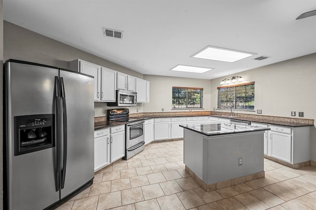 kitchen featuring sink, a center island, white cabinets, and stainless steel appliances