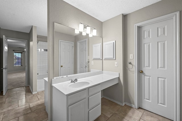 bathroom with vanity, a textured ceiling, plus walk in shower, and tile patterned floors