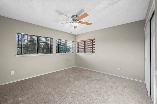 unfurnished room with a textured ceiling, light colored carpet, and ceiling fan