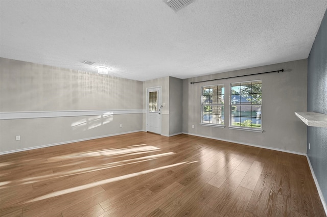 empty room featuring hardwood / wood-style floors and a textured ceiling