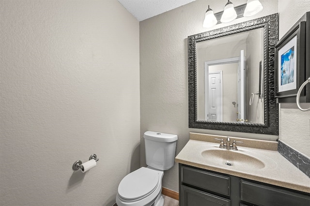 bathroom with toilet, a textured ceiling, and vanity