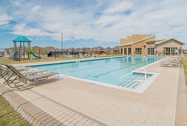 view of swimming pool featuring a playground and a patio