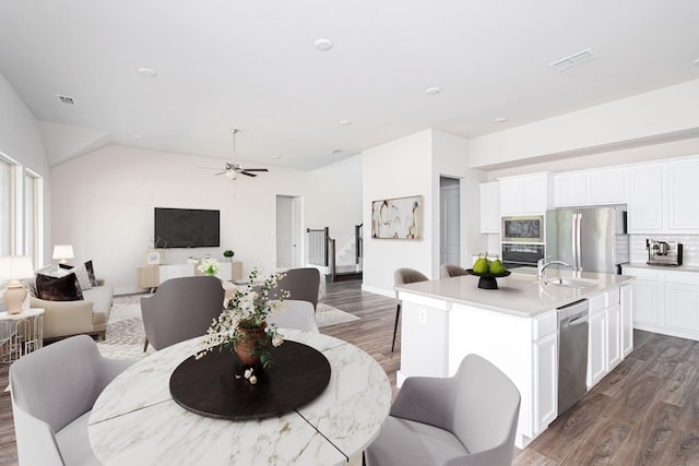 dining area featuring sink, dark wood-type flooring, and ceiling fan