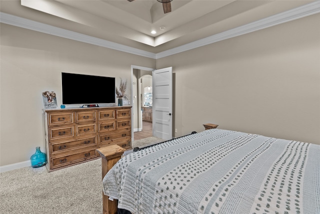 bedroom with crown molding, a tray ceiling, carpet flooring, and ceiling fan