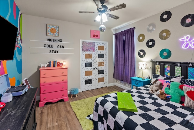 bedroom with dark hardwood / wood-style floors and ceiling fan