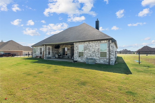 rear view of house with a patio area and a lawn