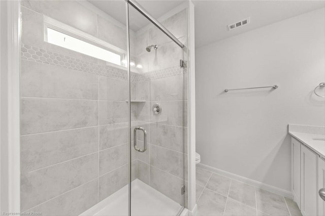 bathroom with toilet, vanity, tile patterned flooring, and a shower with shower door