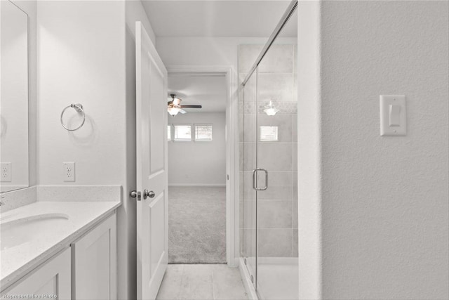 bathroom featuring vanity, ceiling fan, and a shower with shower door