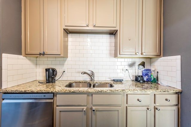 kitchen with stainless steel dishwasher, sink, light stone countertops, and tasteful backsplash