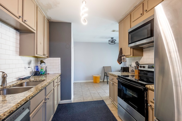 kitchen with decorative backsplash, stainless steel appliances, sink, light stone countertops, and light tile patterned floors