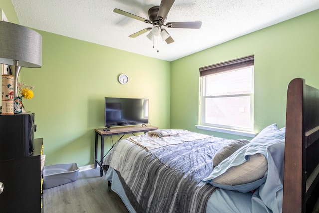 bedroom featuring hardwood / wood-style floors, a textured ceiling, and ceiling fan