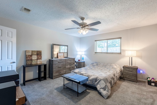 carpeted bedroom with ceiling fan and a textured ceiling