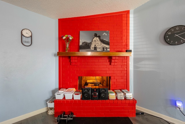 interior details with hardwood / wood-style floors, a textured ceiling, and a brick fireplace