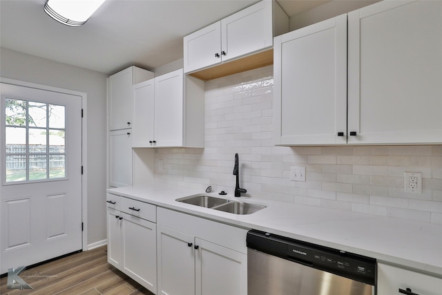 kitchen featuring white cabinetry, dishwasher, sink, and hardwood / wood-style floors