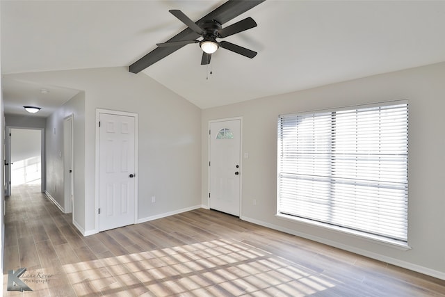 interior space with light hardwood / wood-style floors, lofted ceiling with beams, and ceiling fan