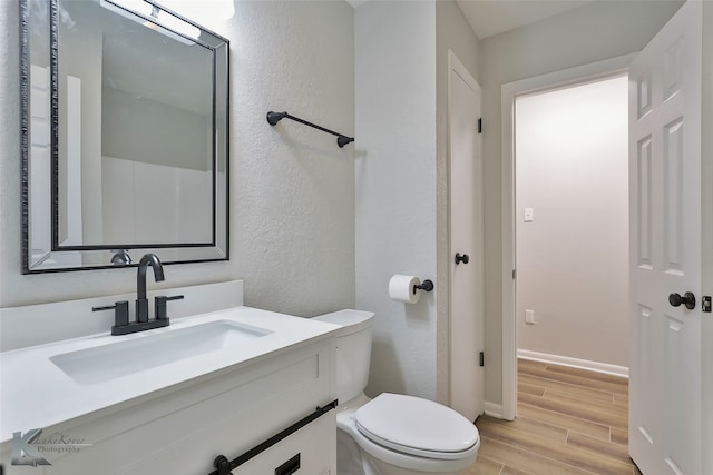 bathroom with vanity, hardwood / wood-style floors, and toilet