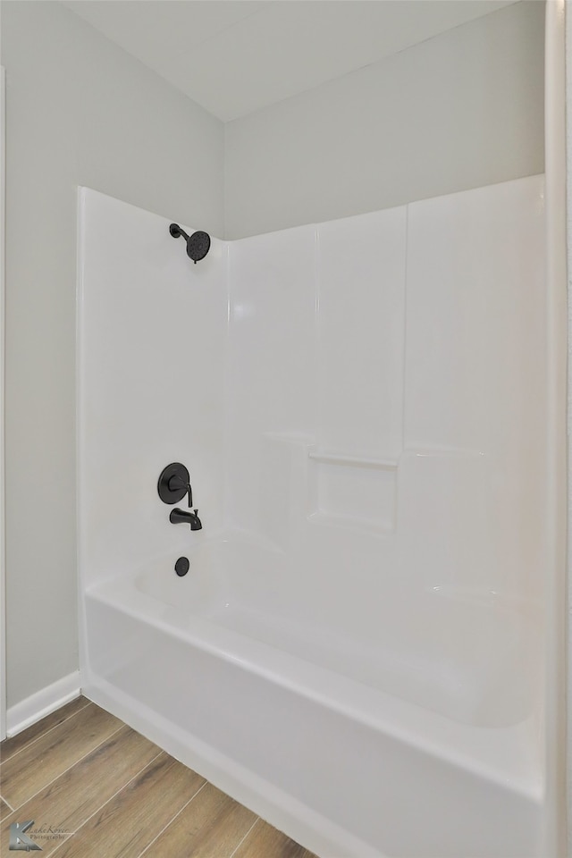 bathroom with shower / bathing tub combination and wood-type flooring