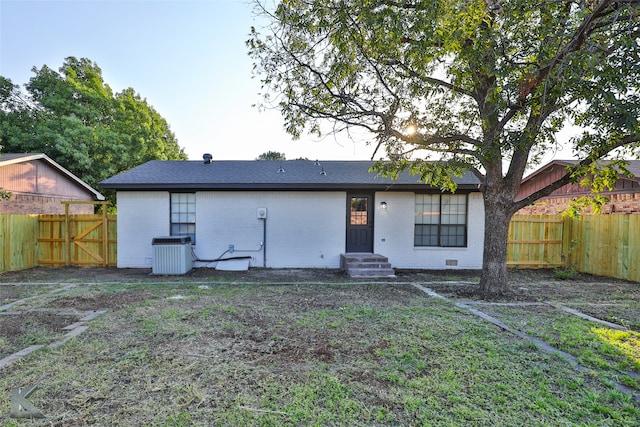 back of property featuring a lawn and central AC unit