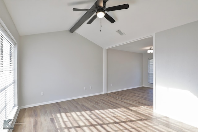 empty room with lofted ceiling with beams, light hardwood / wood-style floors, and ceiling fan