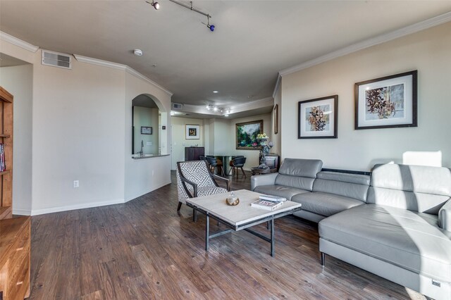 kitchen with sink, light stone counters, light hardwood / wood-style flooring, ornamental molding, and appliances with stainless steel finishes