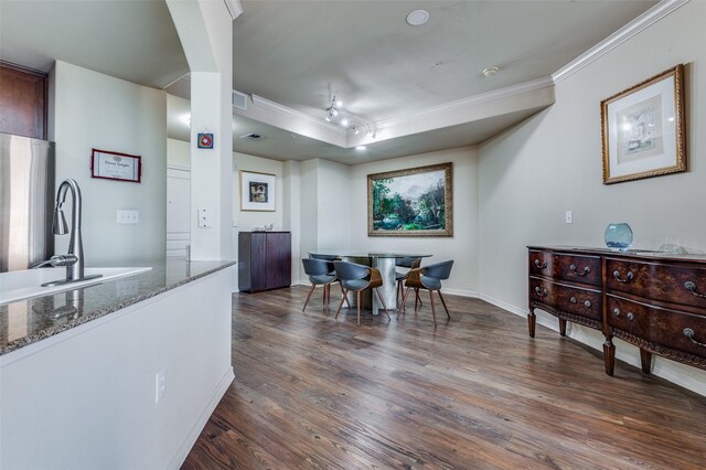 living room with hardwood / wood-style flooring, track lighting, and crown molding