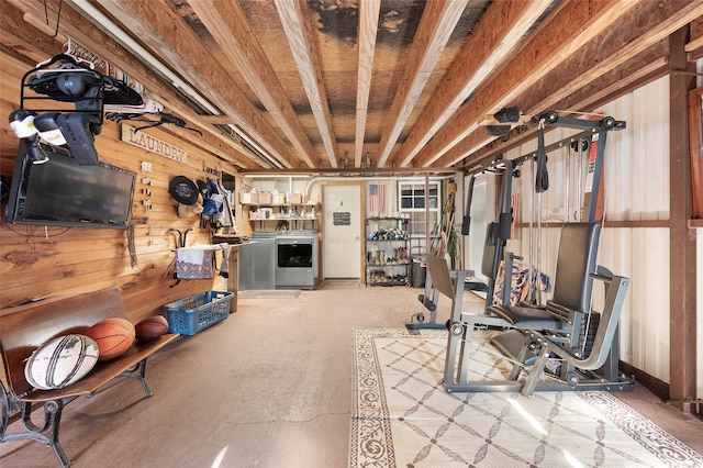 workout area featuring wooden walls and washer / dryer